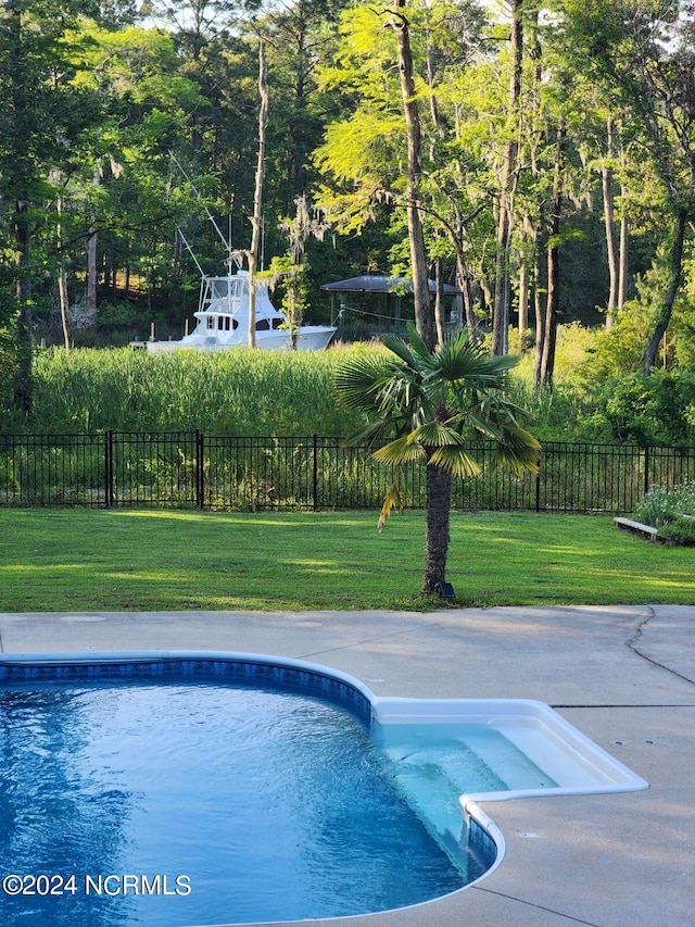 view of swimming pool featuring a yard