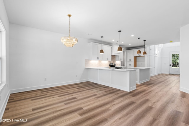 4039 Pintail Ave, Shallotte, NC 28470 - kitchen with light countertops, backsplash, white cabinetry, a peninsula, and recessed lighting