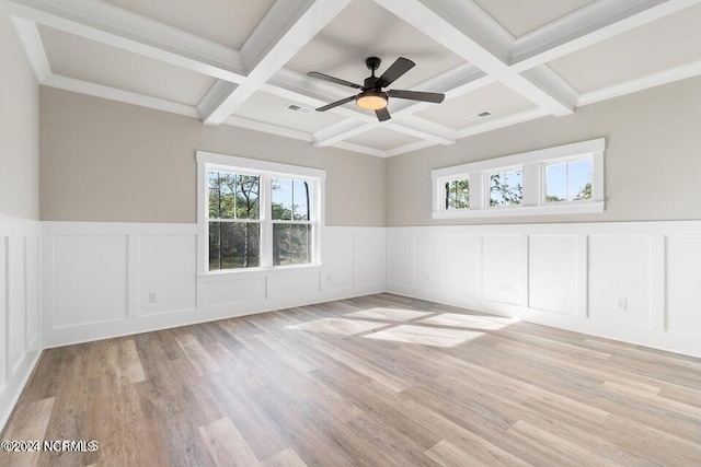 spare room featuring light wood-style floors, visible vents, coffered ceiling, and beamed ceiling