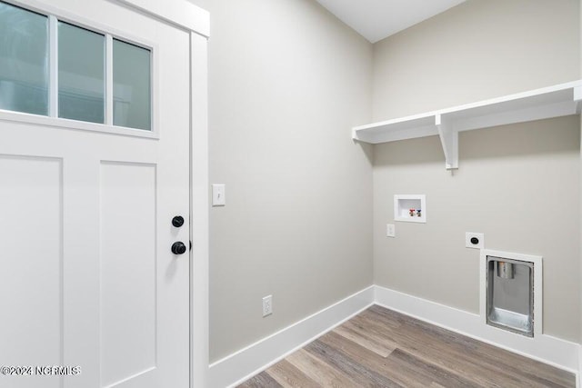 clothes washing area featuring laundry area, baseboards, wood finished floors, hookup for a washing machine, and hookup for an electric dryer