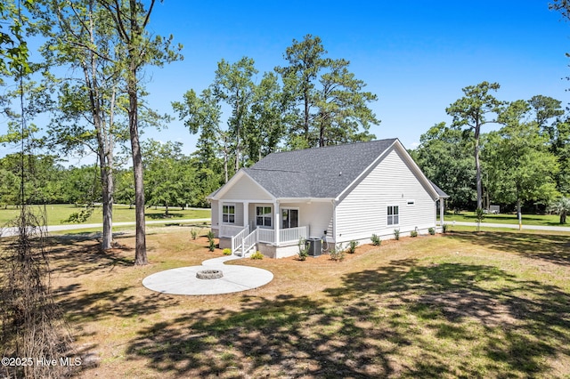 4039 Pintail Ave, Shallotte, NC 28470 - rear view of house with a lawn, roof with shingles, covered porch, and view of scattered trees