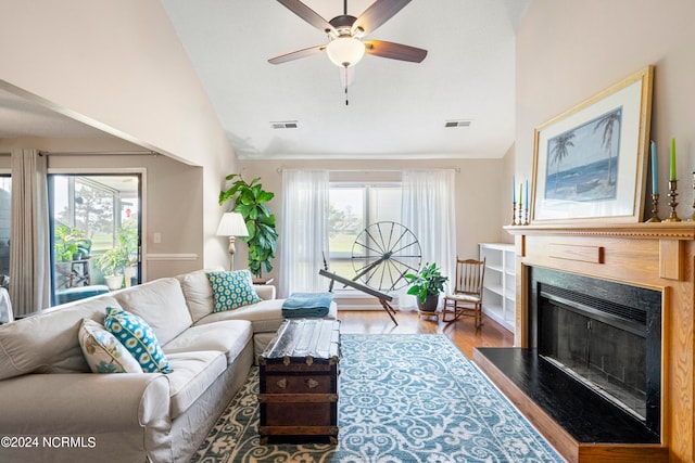 living room featuring light hardwood / wood-style floors, high vaulted ceiling, a healthy amount of sunlight, and ceiling fan