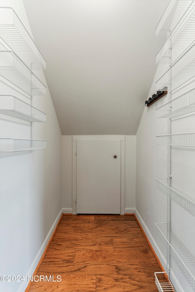 spacious closet featuring vaulted ceiling and light hardwood / wood-style flooring