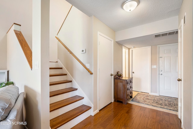 entrance foyer featuring hardwood / wood-style flooring and a textured ceiling