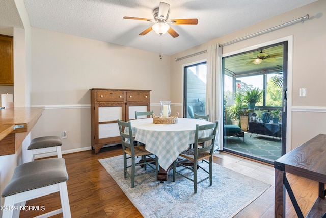 dining area featuring a textured ceiling, wood-type flooring, and ceiling fan