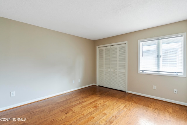 unfurnished bedroom featuring a closet and light hardwood / wood-style flooring