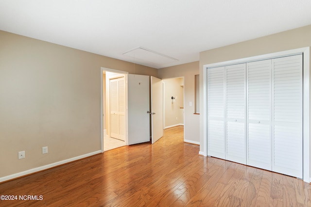 unfurnished bedroom featuring light hardwood / wood-style flooring and a closet