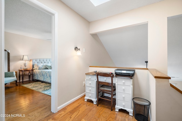 office featuring hardwood / wood-style flooring and a skylight