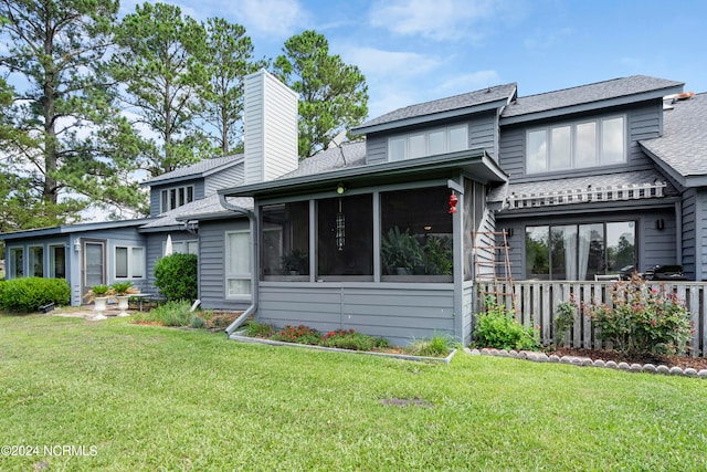 view of front of home featuring a front yard and a sunroom