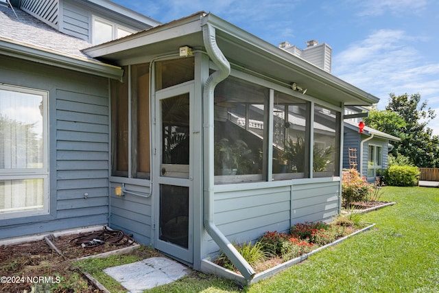 view of side of home featuring a yard and a sunroom