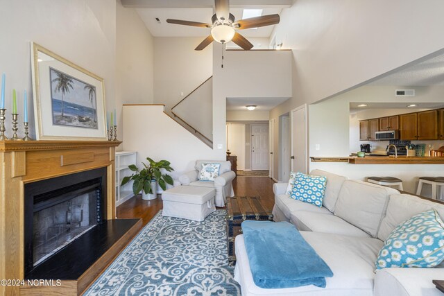 living room featuring sink, wood-type flooring, high vaulted ceiling, and ceiling fan