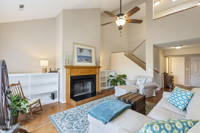 living room with hardwood / wood-style flooring, high vaulted ceiling, and ceiling fan