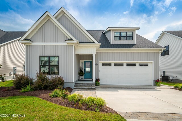 view of front of home featuring central AC unit and a garage