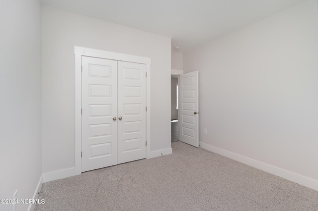 unfurnished bedroom with carpet and a closet