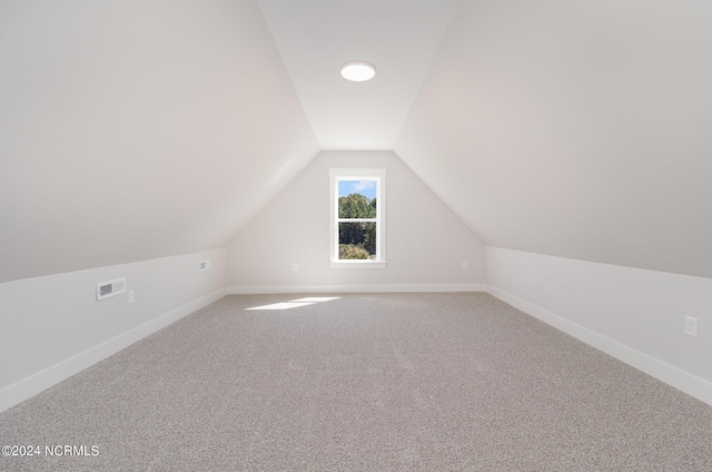 bonus room with carpet flooring and vaulted ceiling