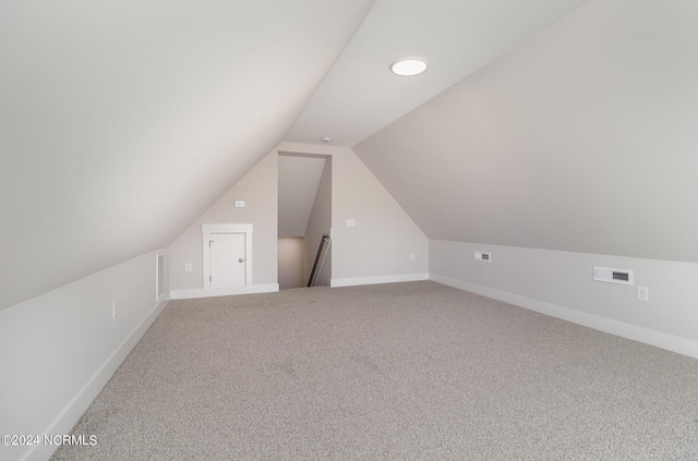 bonus room with vaulted ceiling and carpet flooring