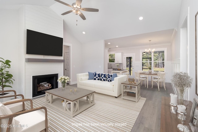 living room featuring ornamental molding, high vaulted ceiling, ceiling fan with notable chandelier, and light wood-type flooring