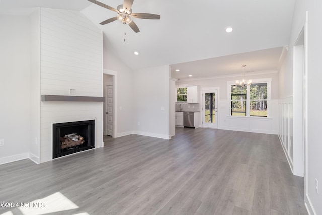 unfurnished living room with ceiling fan with notable chandelier, a fireplace, high vaulted ceiling, and wood-type flooring