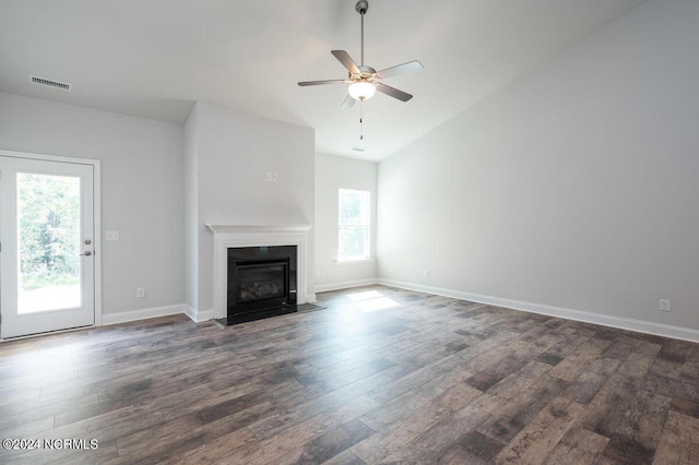unfurnished living room featuring dark wood-style floors, lofted ceiling, a ceiling fan, a fireplace with flush hearth, and baseboards