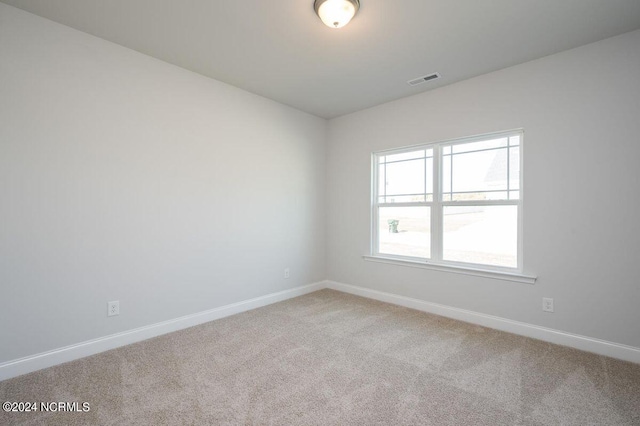 carpeted empty room with visible vents and baseboards