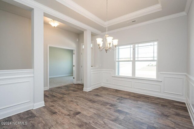 1213 St Simons Dr SE, Bolivia, NC 28422 - unfurnished dining area with a chandelier, dark wood finished floors, a wainscoted wall, a raised ceiling, and ornamental molding