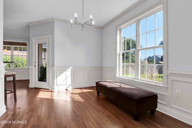 interior space with ornamental molding, an inviting chandelier, and dark wood-type flooring