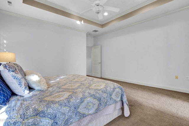 bedroom with ceiling fan, carpet floors, a raised ceiling, and crown molding