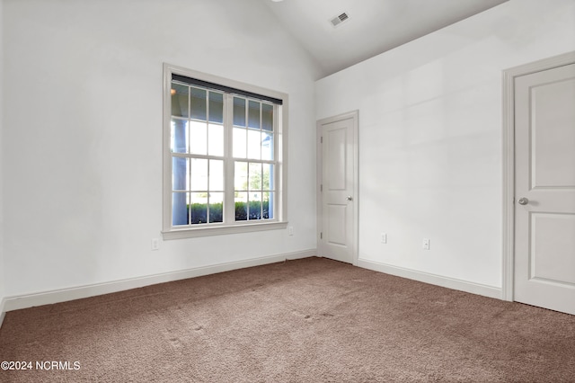 unfurnished room with vaulted ceiling and carpet