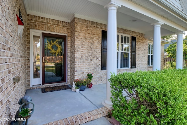 view of exterior entry featuring covered porch