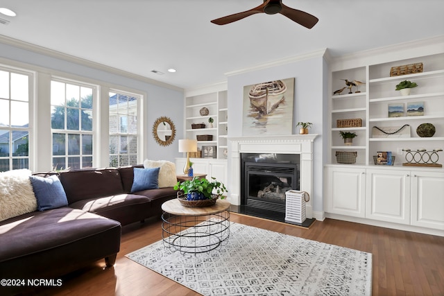 living room featuring ceiling fan, crown molding, dark hardwood / wood-style flooring, and built in features