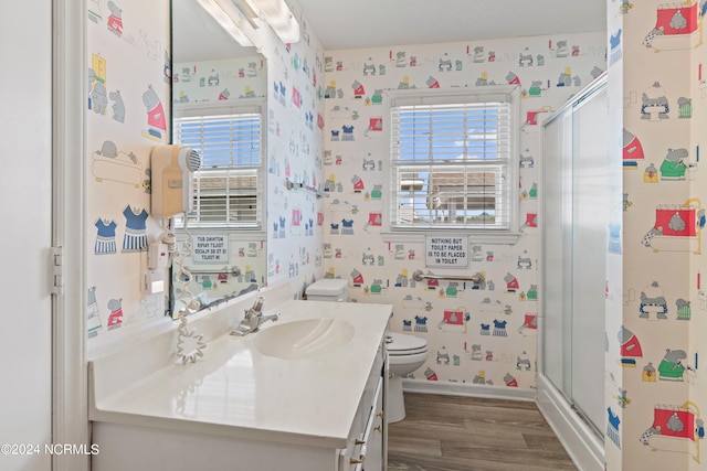 bathroom featuring toilet, walk in shower, vanity, and hardwood / wood-style flooring