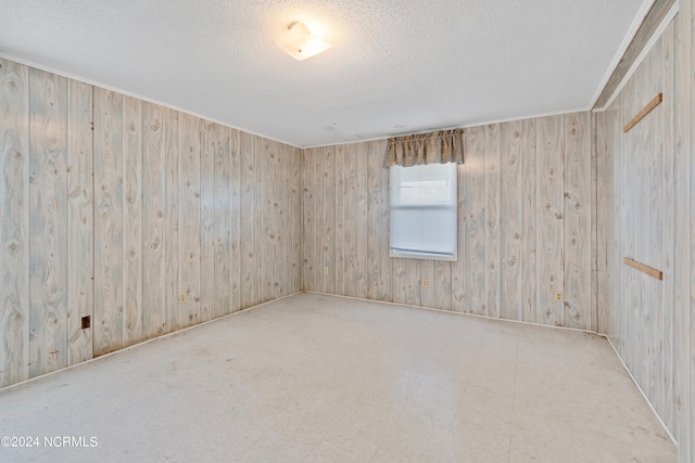 tiled empty room with wooden walls and a textured ceiling