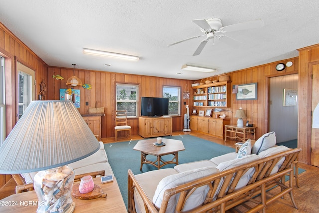 living room with carpet, a textured ceiling, and wooden walls