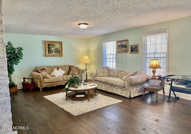 living room with dark wood-style floors, baseboards, and a textured ceiling