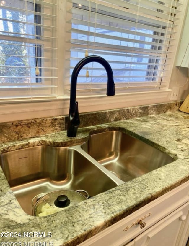 kitchen view of a sink and light stone countertops