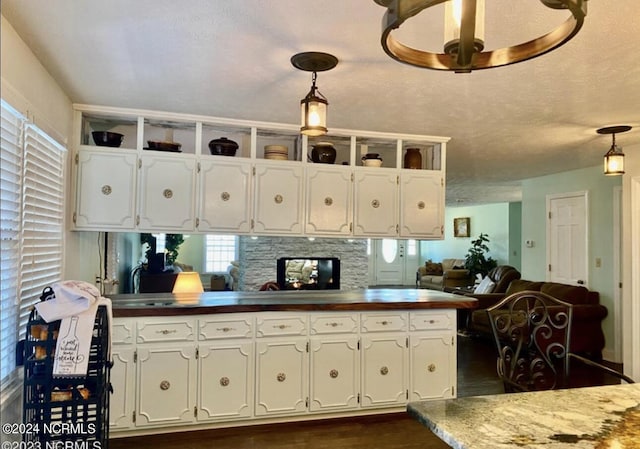 kitchen featuring hanging light fixtures, white cabinetry, and open floor plan