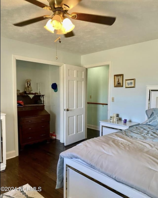 bedroom featuring a ceiling fan, dark wood finished floors, a textured ceiling, and baseboards