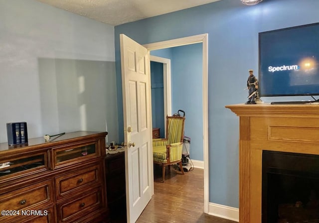 corridor featuring dark wood finished floors and baseboards