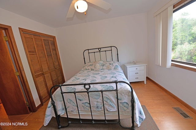 bedroom featuring visible vents, ceiling fan, baseboards, and wood finished floors