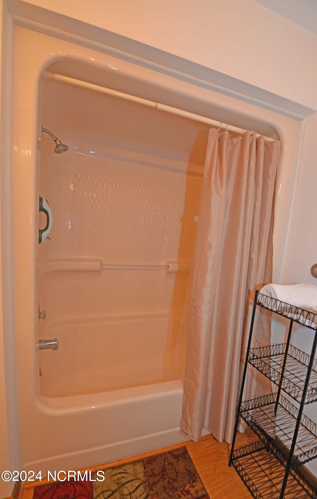 bathroom featuring shower / tub combo and wood finished floors