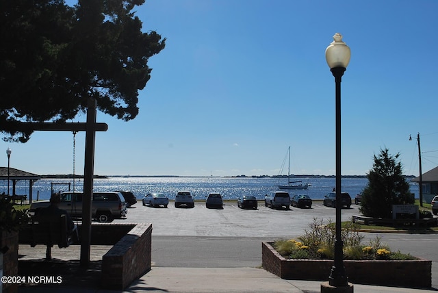 surrounding community featuring uncovered parking and a water view