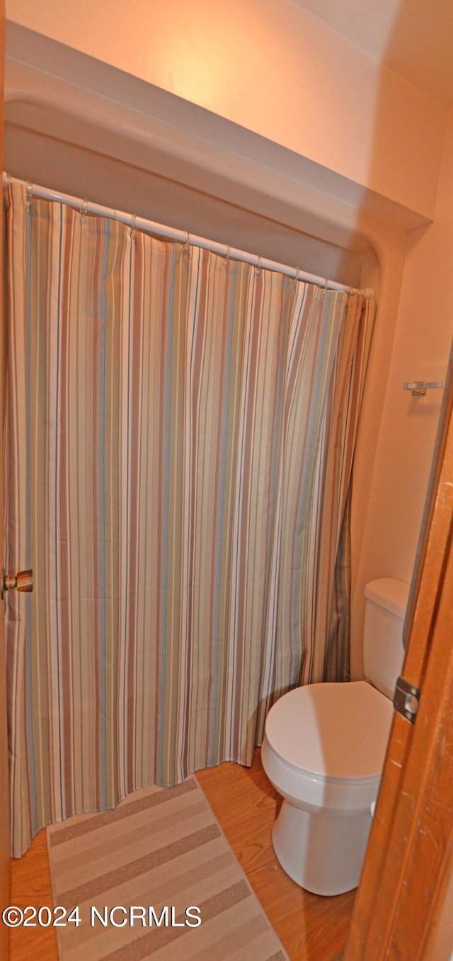 bathroom featuring wood finished floors and toilet