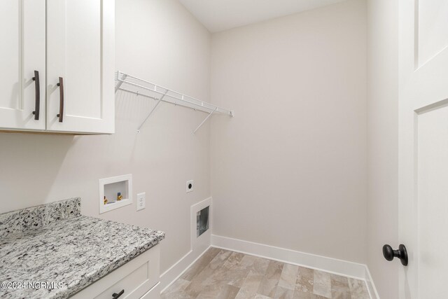 washroom featuring hookup for a washing machine, hookup for an electric dryer, and cabinets