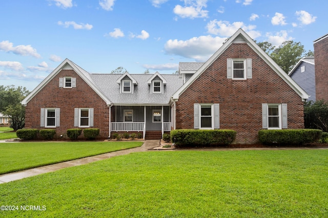 view of front of house featuring a porch, brick siding, and a front lawn