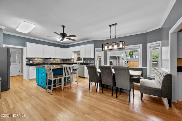 kitchen featuring pendant lighting, dark countertops, freestanding refrigerator, and white cabinets
