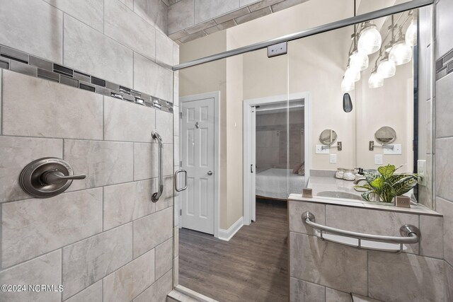 bathroom featuring a shower with shower door, vanity, and hardwood / wood-style floors