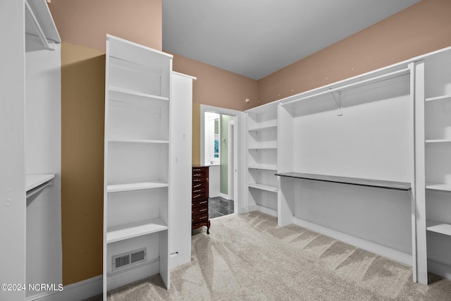 walk in closet with light colored carpet and visible vents