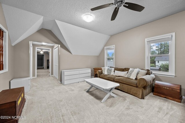 carpeted living room featuring ceiling fan, a textured ceiling, and lofted ceiling