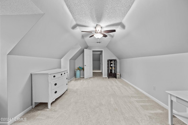 bonus room with light carpet, a textured ceiling, lofted ceiling, and ceiling fan