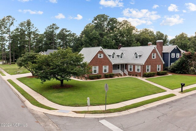 view of front of house with a front lawn and brick siding